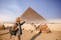Tourist man in hat with camel background pyramid of Egyptian Giza, sunset Cairo, Egypt Royalty Free Stock Photo