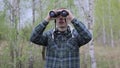Tourist man looking through binoculars