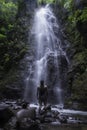 Tourist man looking at a waterfall surrounded by vegetation in the middle of the humid tropical jungle of Costa Rica Royalty Free Stock Photo