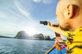 Tourist man with photo camera in hand enjoying his trip on the long tail boat on Phang Nga bay in Thailand. Fascinating view of Royalty Free Stock Photo