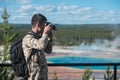 Tourist man photographer taking photos and enjoy the view of mountains in Yellowstone National Park Royalty Free Stock Photo