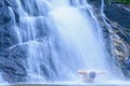 Tourist man relaxing under flowing waterfall nature. Nature Therapy. Royalty Free Stock Photo