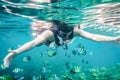 Tourist man snorkeling with school of fish in tropical sea Royalty Free Stock Photo