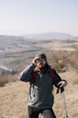 Tourist man standing on hill with mountain view and using binoculars Royalty Free Stock Photo