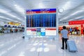 Tourist man standing with his luggage and checking the flight on the departure time board