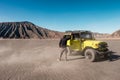 Tourist man standing on yellow four wheel car in desert Royalty Free Stock Photo