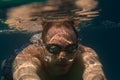 Tourist man in swimming sports glasses swimming underwater in the Aegean Sea on the coast of Sithonia Peninsula Royalty Free Stock Photo