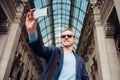 Tourist man take his photo in Galleria Vittorio Emanuele in Milan