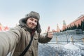 Tourist man takes a photo of himself against the background of a red square in winter in Moscow, Russia Royalty Free Stock Photo