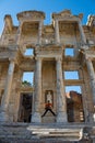 A tourist man is taking Ephesus Celsus Library`s photo in a rainy day