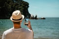 Tourist man taking a picture with mobile at Split Apple Rock. Abel Tasman National Park, New Zealand Royalty Free Stock Photo