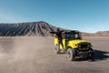 Tourist man thumb a lift on yellow four wheel car in desert Royalty Free Stock Photo