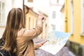 Tourist with map in the city. Woman pointing at right direction