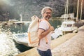 Tourist mature man standing with map and backpack near the sea Royalty Free Stock Photo