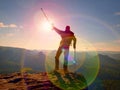 Tourist with medicine crutch above head achieve mountain peak. Hurt backpacker with broken leg Royalty Free Stock Photo