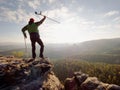 Tourist with medicine crutch above head achieve mountain peak. Hurt backpacker with broken leg