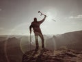 Tourist with medicine crutch above head achieve mountain peak. Hurt backpacker with broken leg Royalty Free Stock Photo