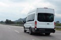 Tourist minibus in motion on background mountains