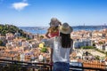 A tourist mother and her little daughter enjoy the view of the beautiful cityscape of Lisbon