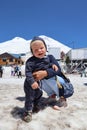 Tourist mother and little son on the snowy slope of mountain Elbrus in Russia