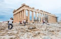 Tourist in multiple exposure posing in various poses in front of the famous Parthenon on Acropolis hill. the temple is under