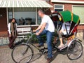 Tourist negotiating price on bike taxi, Volendam