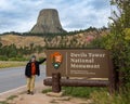 A tourist next the sign of Devils Tower National Monument in Wyoming Royalty Free Stock Photo