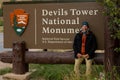 A tourist next the sign of Devils Tower National Monument in Wyoming