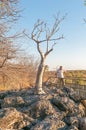 Tourist next to moringa tree at the waterhole at Halali