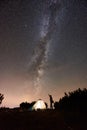 Tourist at night camping on top of mountain under starry sky Royalty Free Stock Photo