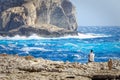 Tourist observe the rough seas of Dwejra Bay in Gozo, Malta