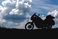 Tourist off road motorcycle with side bags, rider to rest during the trip to see the light of nature, silhouette wallpaper concept Royalty Free Stock Photo