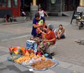 A tourist and a old people talk about commodities selling arts and crafts