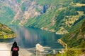 Tourist over fjord wearing norwegian flag clothing