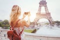 Tourist in Paris visiting landmark Eiffel tower, sightseeing in France, mobile photo on smartphone