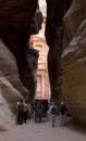 Tourist people walking at the entrance to petra monument through a rocky canyon , unesco world heritage site in Jordan