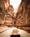 Tourist in Petra take photograph of The Siq, the narrow slot-canyon that serves as the entrance passage to the hidden city of