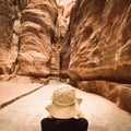 Tourist in Petra take photograph of The Siq, the narrow slot-canyon that serves as the entrance passage to the hidden city of