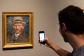 tourist photographing Vincent Van Gogh self-portrait in Amsterdam
