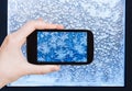 Tourist photographs snowflakes and frost on window