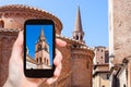 tourist photographs tower and Rotonda in Mantua