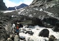 Tourist with a piece of an ice on a background of a thawing glacier in Altay mountains