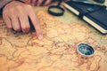 Tourist planning vacation, holiday with the help world map and compass. Man`s hand marks route on map and using pins and rope. Royalty Free Stock Photo