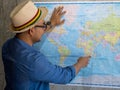 Tourist pointing at worldmap for next destination.