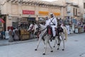 Doha, Qatar - Oct 17, 2022: Tourist police in traditional Qatari dress patrolling along the walkway in Souq Wakif.