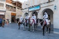 Doha, Qatar - Oct 17, 2022: Tourist police in traditional Qatari dress patrolling along the walkway in Souq Wakif.