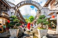 Tourist posing in middle of round stone gate in scenic pedestrian street of Dali old town Yunnan China