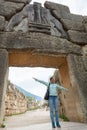 Tourist posing under famous Lion gate entrance.