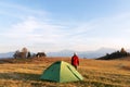 Tourist in red jacket near his tent in mountains camp Royalty Free Stock Photo