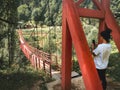 Tourist by red old metal structure with wooden pathway bridge in nature in Georgia countryside. Adjara hidden gems